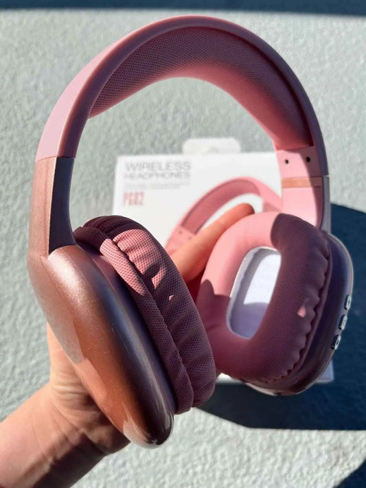 Pink PG02 wireless headphones are held in hand from a different angle.