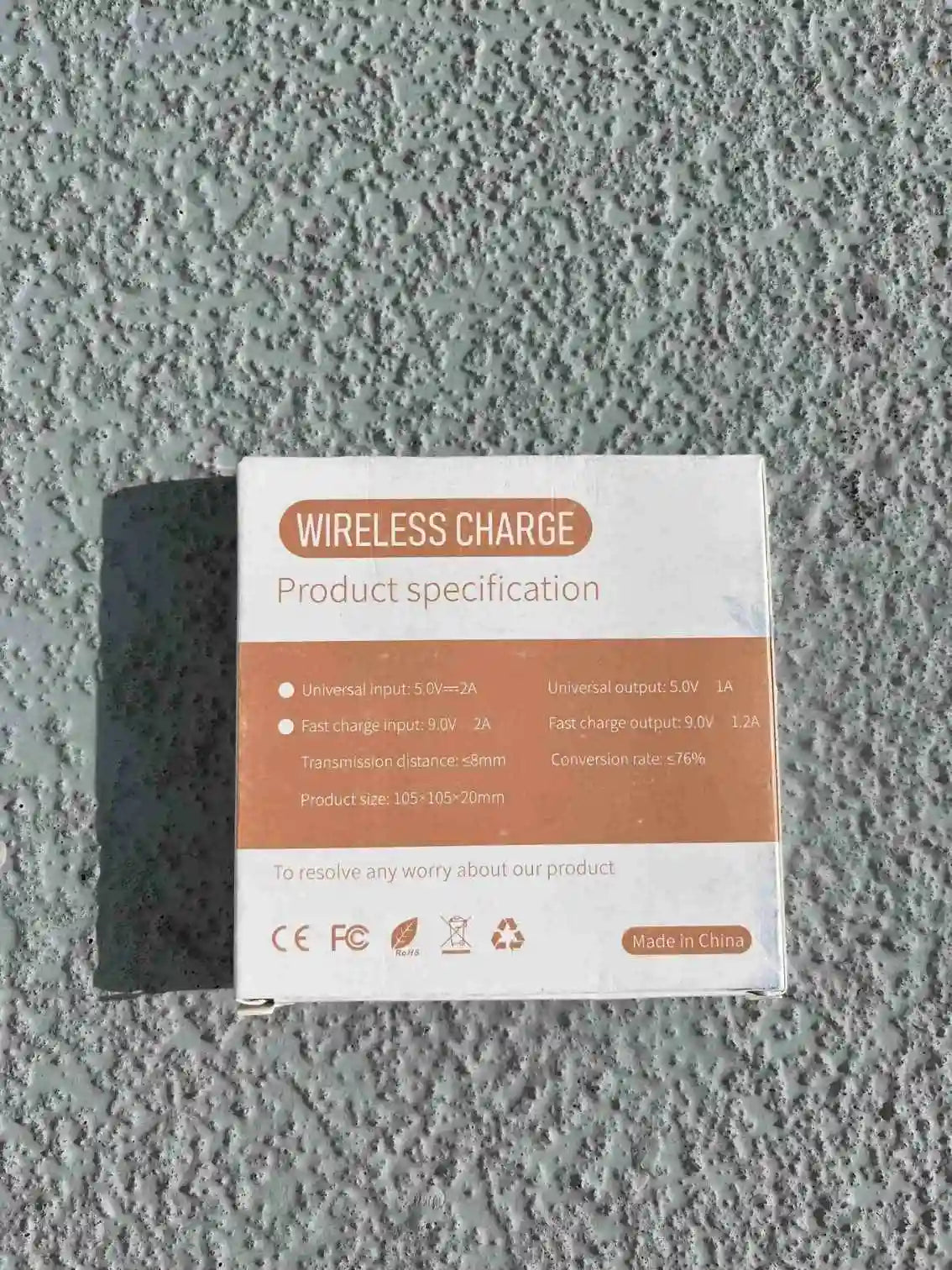 Back view of wireless charger packaging showing product specifications, input/output details, and Qi standard compatibility.