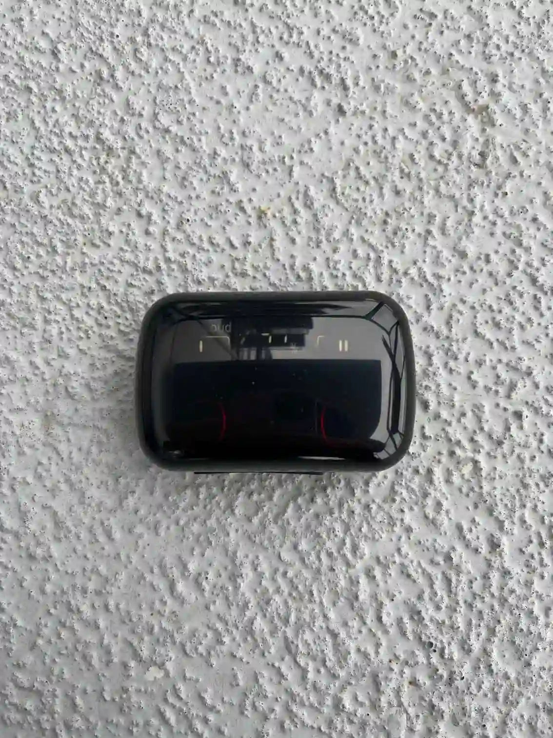 Compact wireless earbuds charging case with a glossy finish, designed for portability and protection.