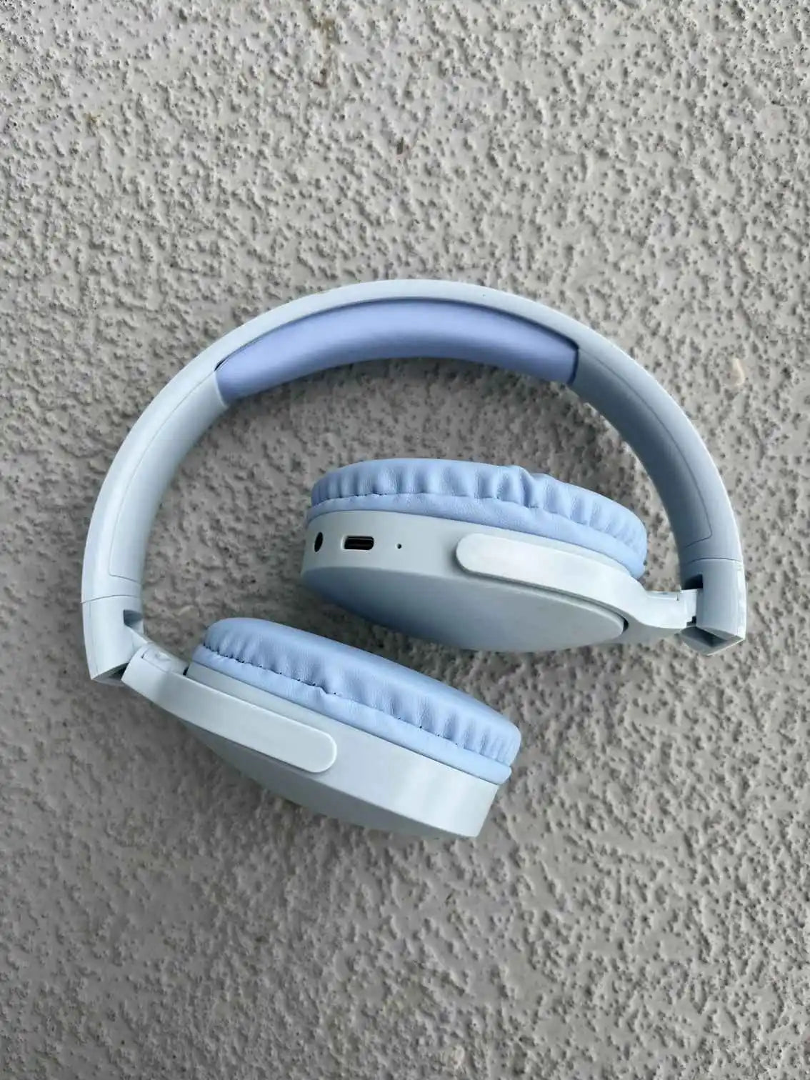 Folded blue wireless headphones with padded ear cups and adjustable headband.