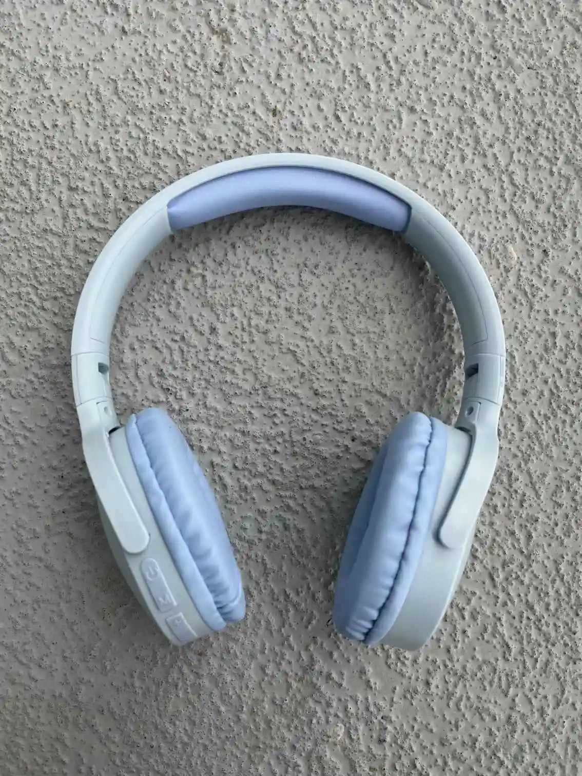 Blue wireless headphones side view with padded ear cups and controls.