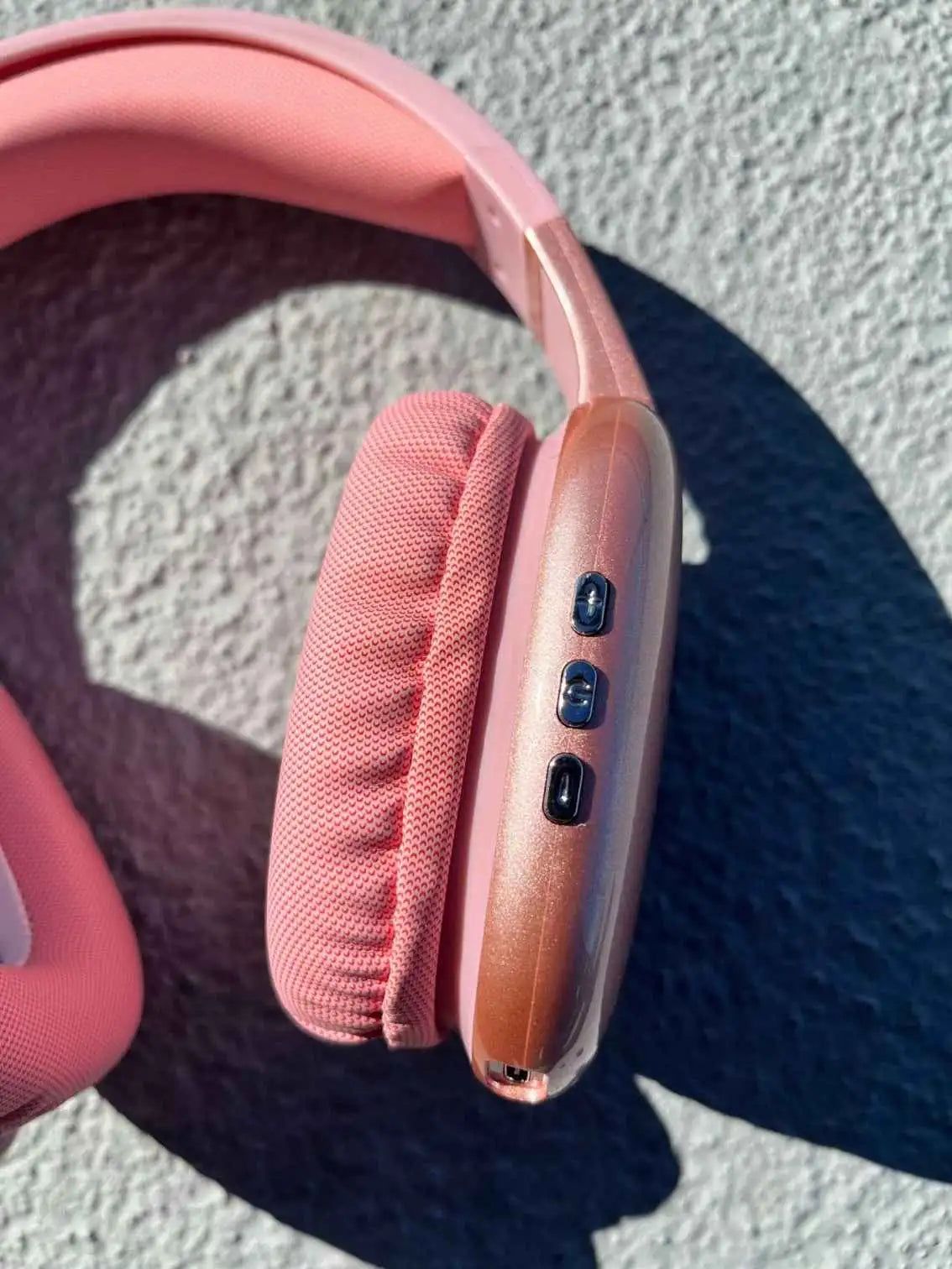 Close-up of the red wireless PG02 Bluetooth headphones with control buttons on the side, featuring soft ear cushions.