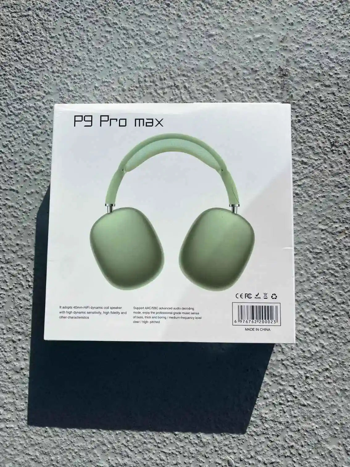 Green P9 Pro Max headphones in box.