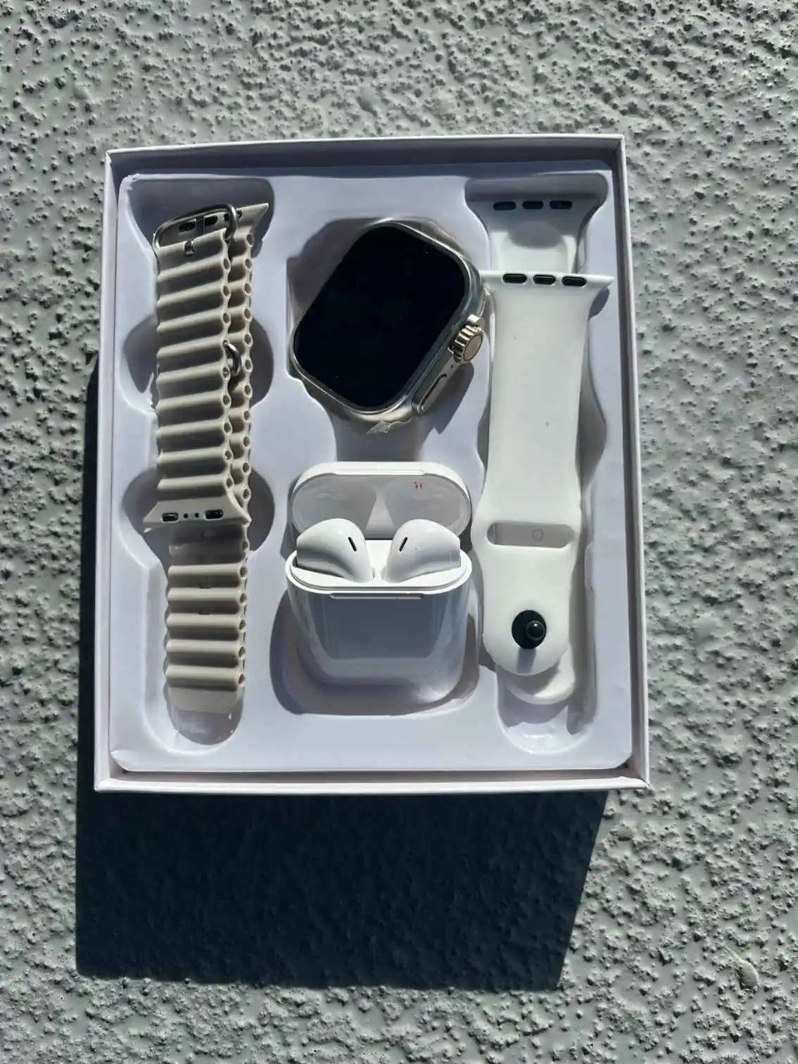 Wireless earbuds and i8 Ultra smartwatch set with additional wristband, displayed in original packaging box.