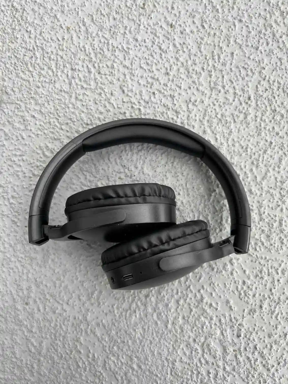 Foldable black over-ear wireless headphones with cushioned ear pads for ultimate comfort and portability.