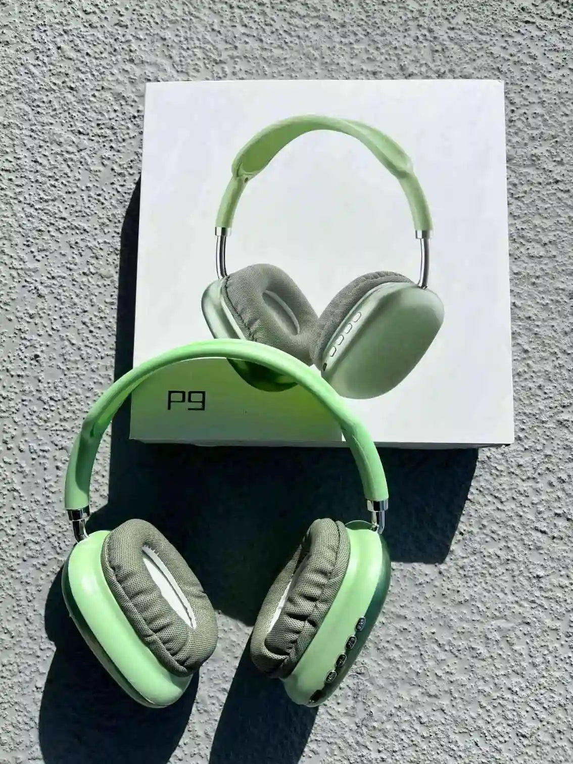 Stylish p9 wireless over-ear headphones in green colour, on the box.