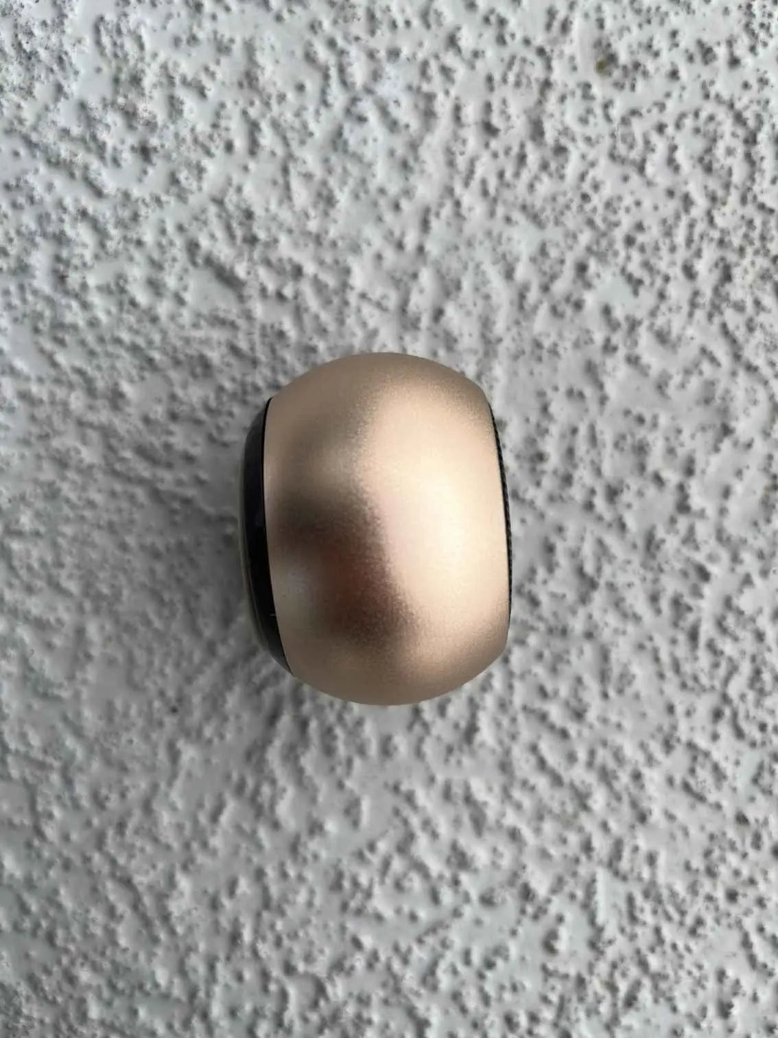 Side view of mini rose gold Bluetooth speaker.