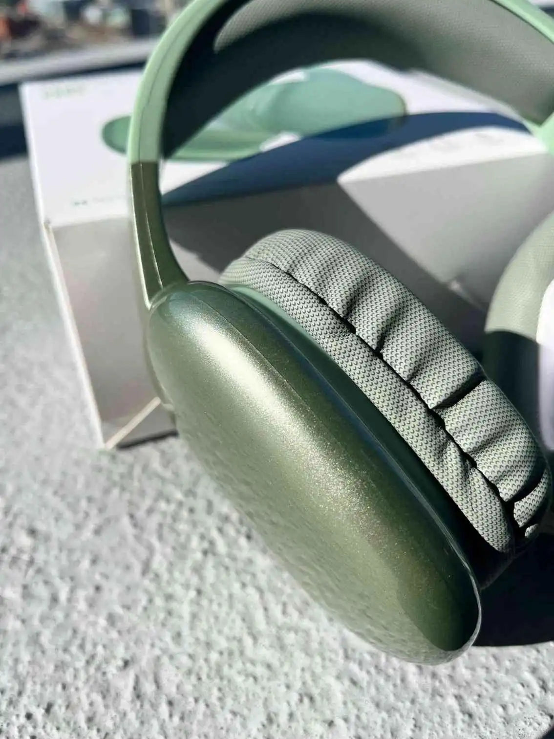 Green wireless noise-cancelling Bluetooth headphones PG02 with soft ear cushions.