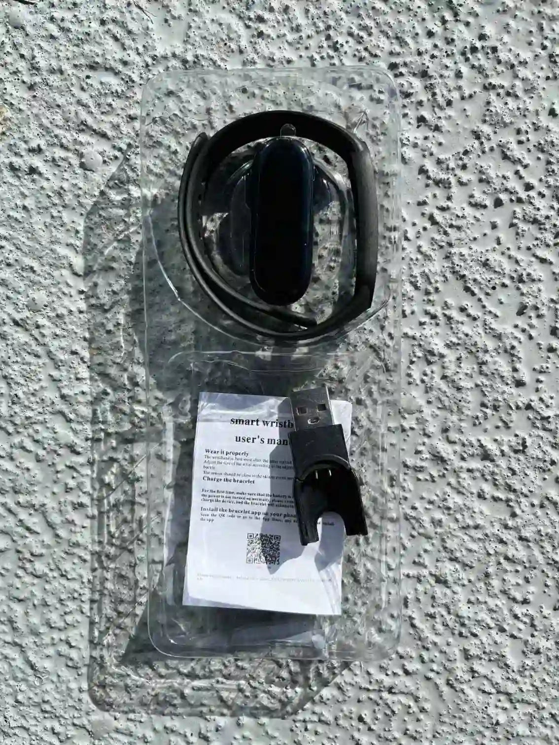 Smart Band 8 black smartwatch with charging cable and user manual, packaged for easy setup and use.