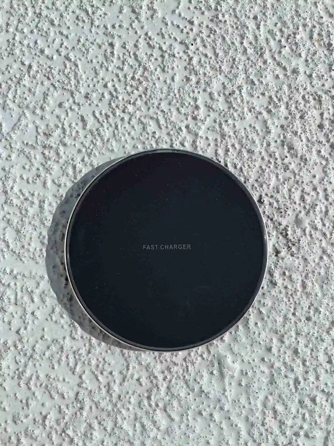 Black wireless fast charger with sleek design.