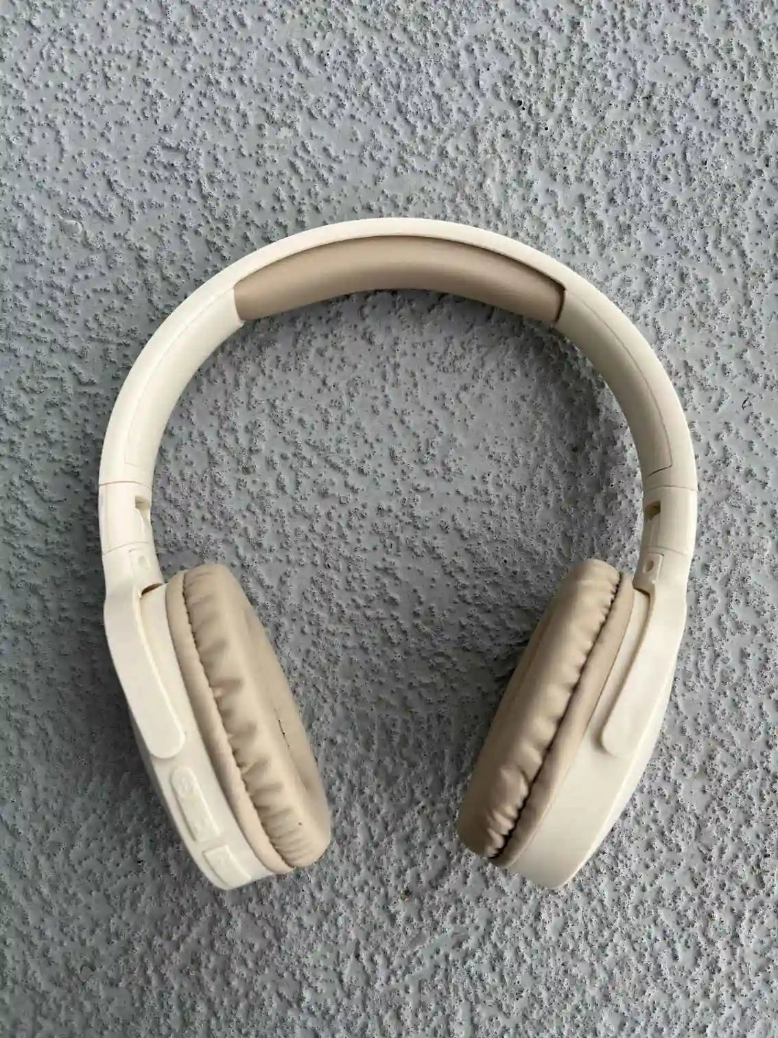 Cream wireless headphones front view.