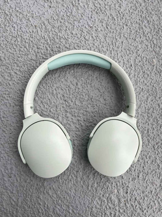 Wireless mint green Bluetooth headphones with a modern design on a textured gray background, ideal for music lovers.